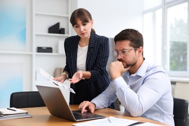 Photo of Consultant working with client at table in office. Business meeting
