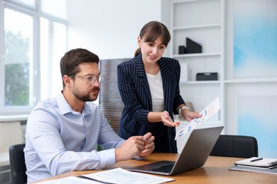 Photo of Consultant working with client at table in office. Business meeting