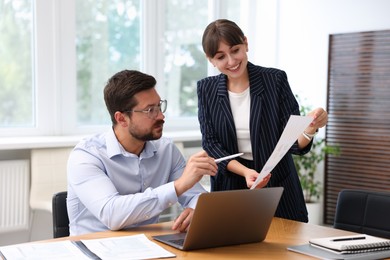 Photo of Consultant working with client at table in office. Business meeting