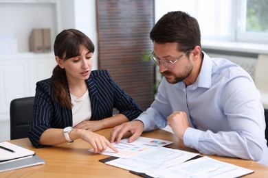 Photo of Consultant working with client at table in office. Business meeting