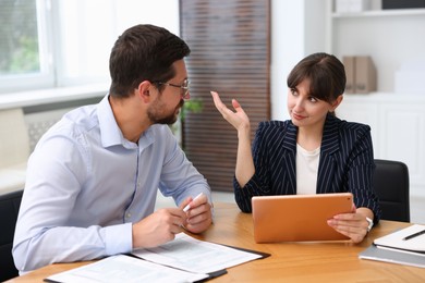 Photo of Consultant working with client at table in office. Business meeting