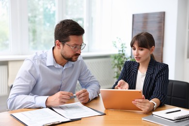 Photo of Consultant working with client at table in office. Business meeting