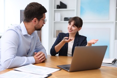 Photo of Consultant working with client at table in office. Business meeting