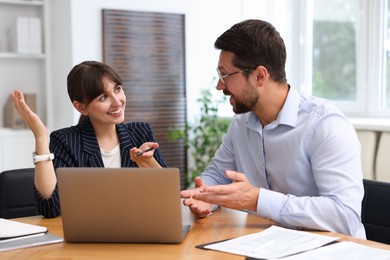 Photo of Consultant working with client at table in office. Business meeting
