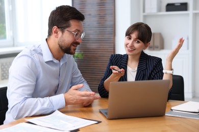Photo of Consultant working with client at table in office. Business meeting