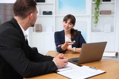 Photo of Consultant working with client at table in office. Business meeting