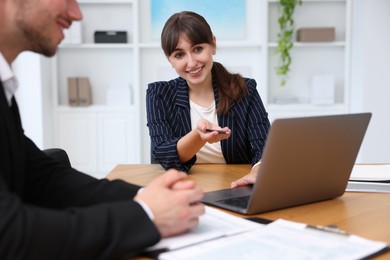Photo of Consultant working with client at table in office. Business meeting