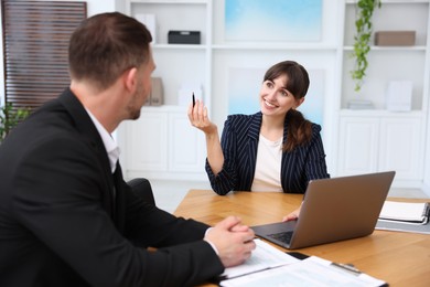 Photo of Consultant working with client at table in office. Business meeting