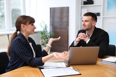 Photo of Consultant working with client at table in office. Business meeting