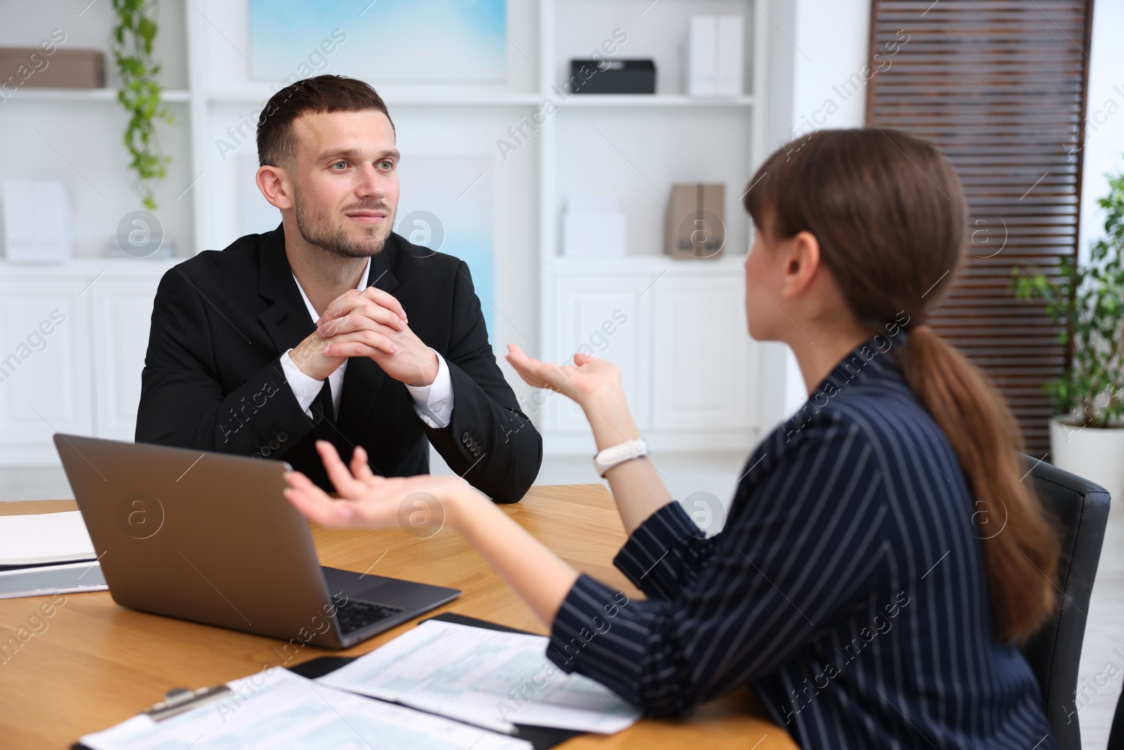 Photo of Consultant working with client at table in office. Business meeting