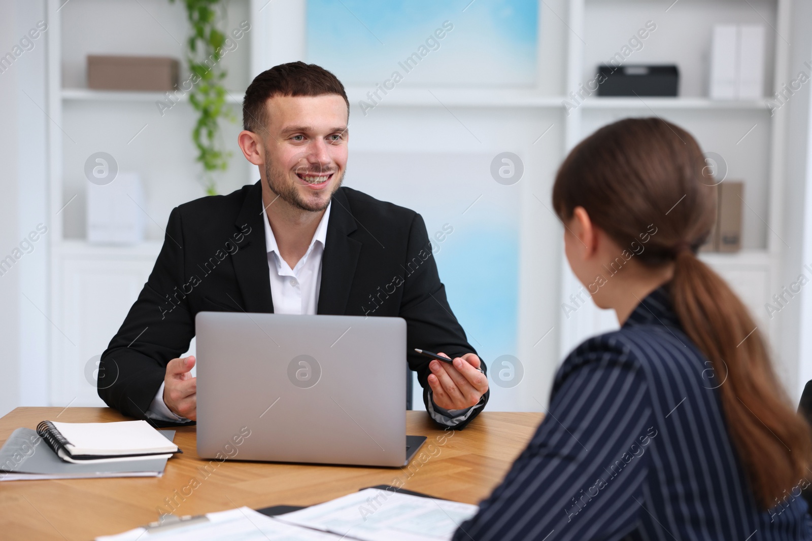 Photo of Consultant working with client at table in office. Business meeting