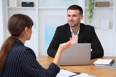 Photo of Consultant working with client at table in office. Business meeting