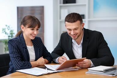 Photo of Consultant working with client at table in office. Business meeting