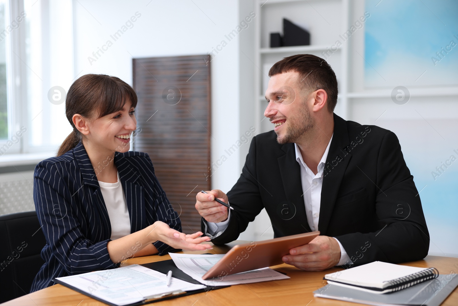 Photo of Consultant working with client at table in office. Business meeting