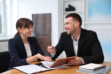 Photo of Consultant working with client at table in office. Business meeting