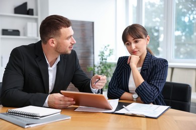 Photo of Consultant working with client at table in office. Business meeting