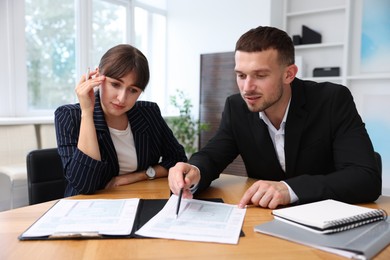 Photo of Consultant working with client at table in office. Business meeting