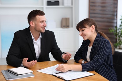 Photo of Consultant working with client at table in office. Business meeting