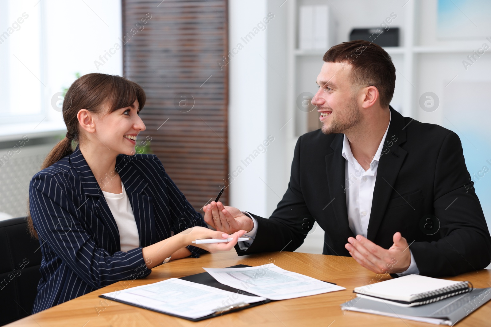 Photo of Consultant working with client at table in office. Business meeting