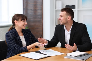 Photo of Consultant working with client at table in office. Business meeting
