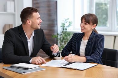Photo of Consultant working with client at table in office. Business meeting