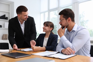 Photo of Couple having meeting with business consultant at table in office