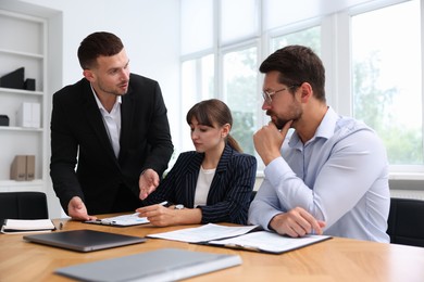 Photo of Couple having meeting with business consultant at table in office