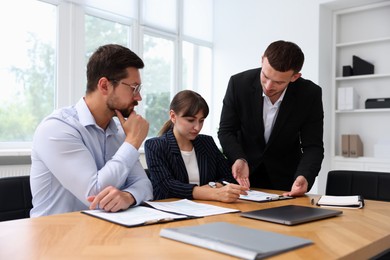 Photo of Couple having meeting with business consultant at table in office
