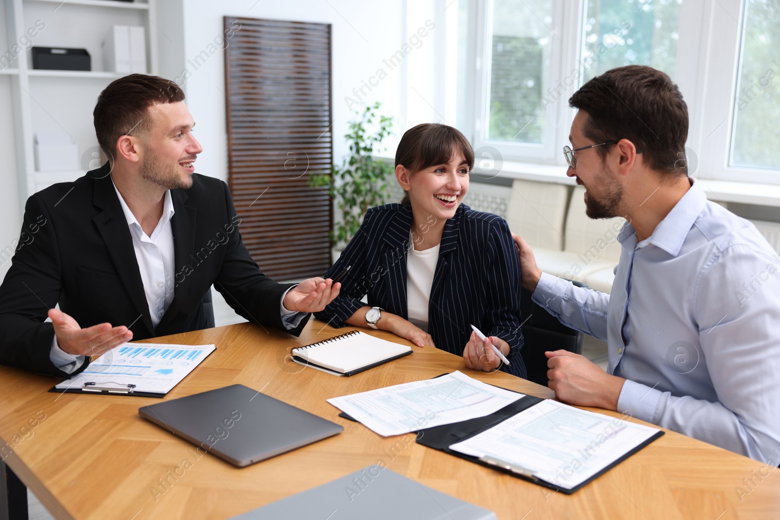 Photo of Couple having meeting with business consultant at table in office