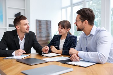 Photo of Couple having meeting with business consultant at table in office