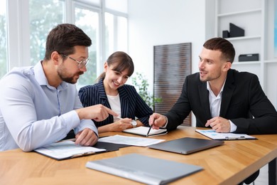 Photo of Couple having meeting with business consultant at table in office