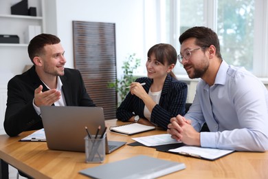 Photo of Couple having meeting with business consultant at table in office