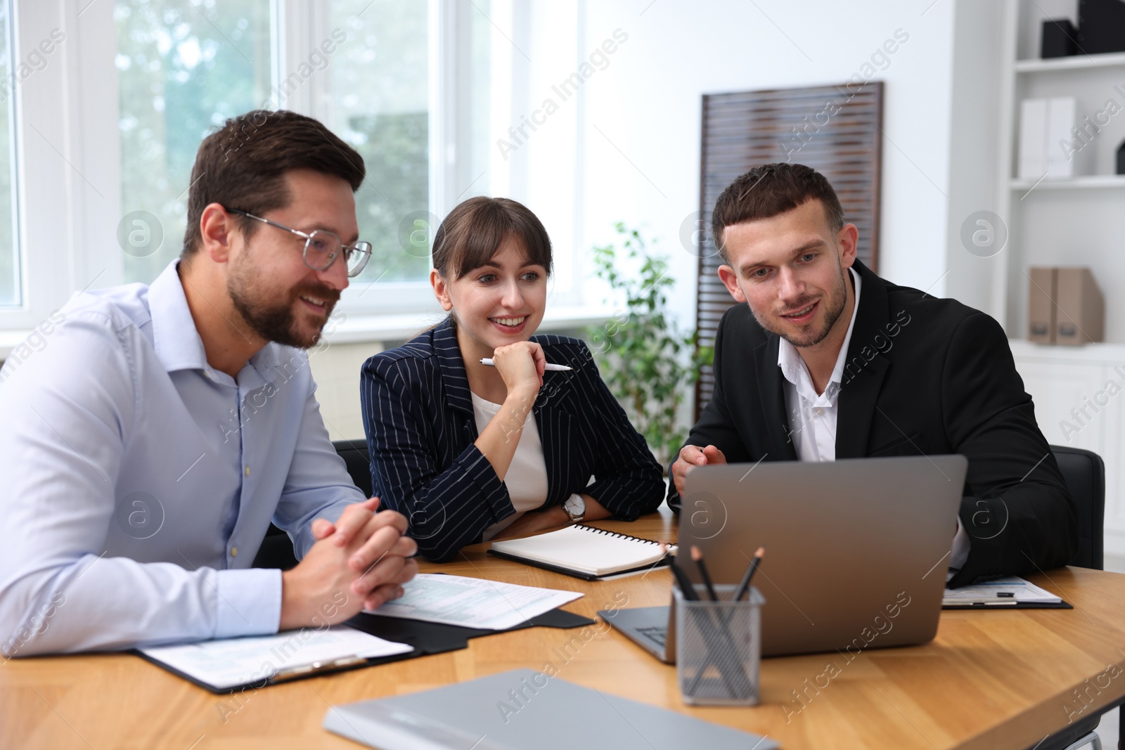 Photo of Couple having meeting with business consultant at table in office