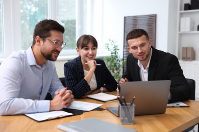 Photo of Couple having meeting with business consultant at table in office