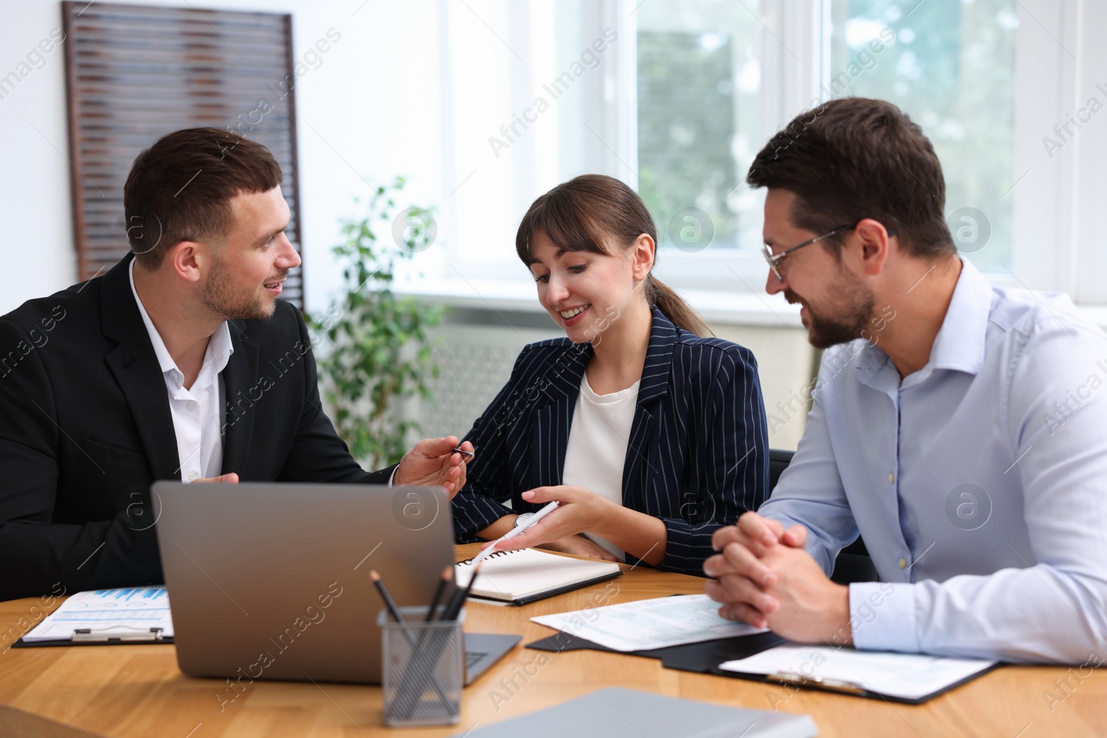 Photo of Couple having meeting with business consultant at table in office