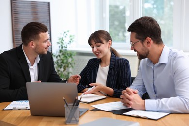 Photo of Couple having meeting with business consultant at table in office