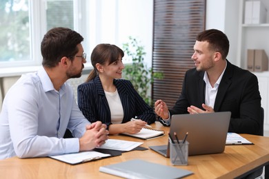 Photo of Couple having meeting with business consultant at table in office