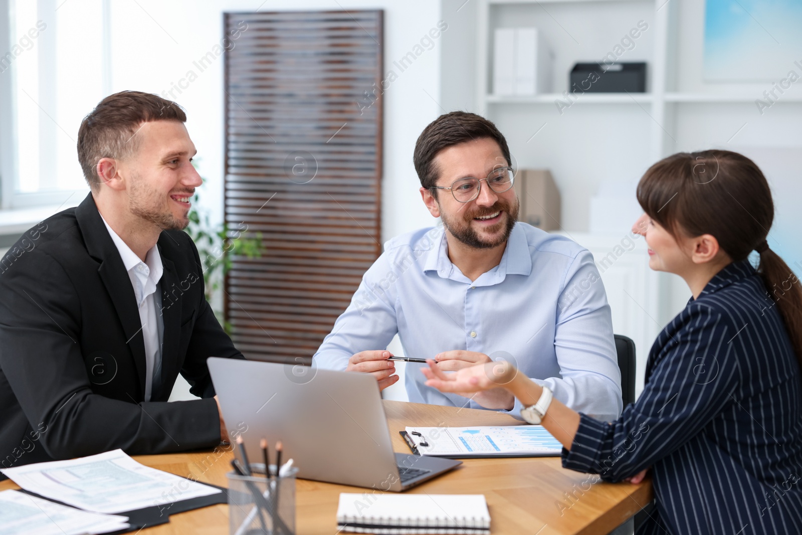 Photo of Couple having meeting with business consultant at table in office
