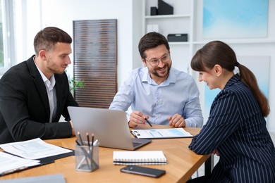 Photo of Couple having meeting with business consultant at table in office