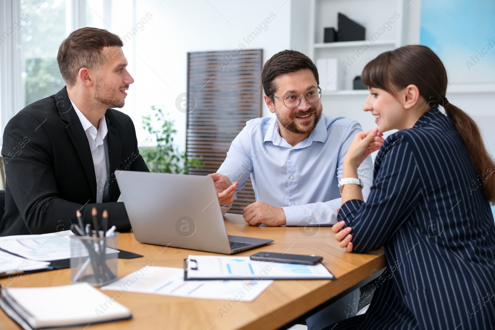Photo of Couple having meeting with business consultant at table in office