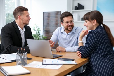 Photo of Couple having meeting with business consultant at table in office