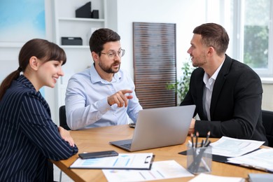Photo of Couple having meeting with business consultant at table in office