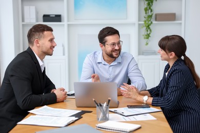 Photo of Couple having meeting with business consultant at table in office