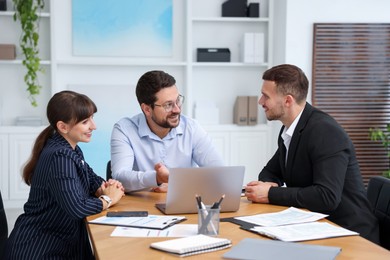 Photo of Couple having meeting with business consultant at table in office