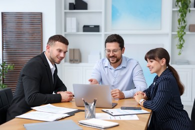 Photo of Couple having meeting with business consultant at table in office