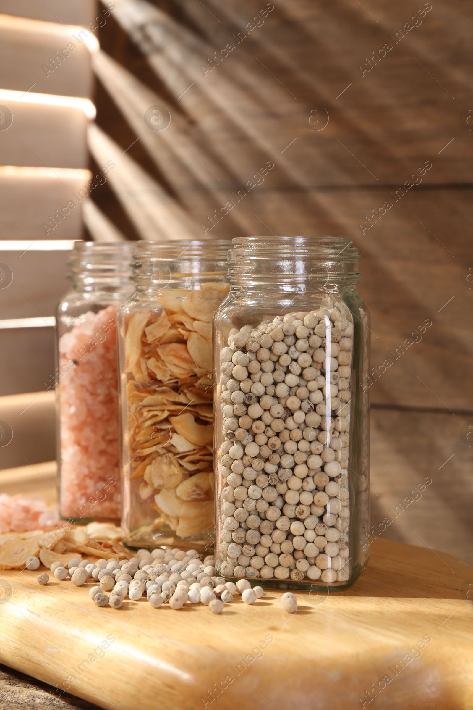 Different aromatic spices in glass jars on wooden table, closeup Photo of Different aromatic spices in glass jars on wooden table, closeup
