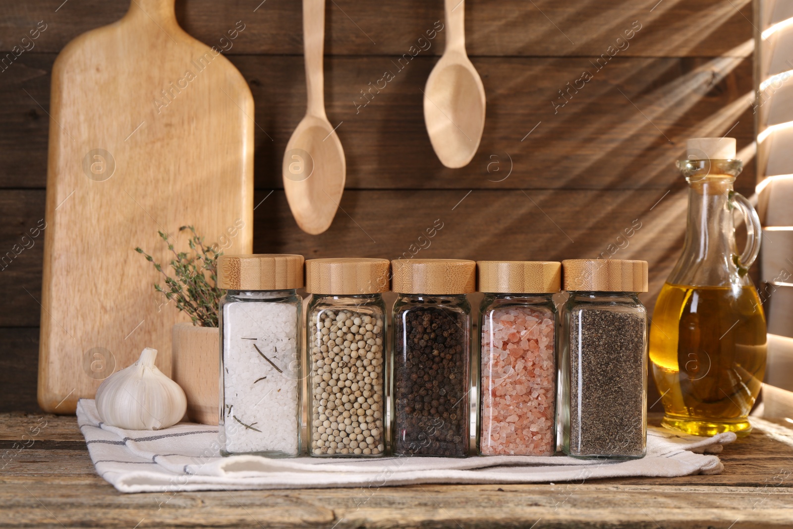 Different aromatic spices in glass jars on wooden table Photo of Different aromatic spices in glass jars on wooden table