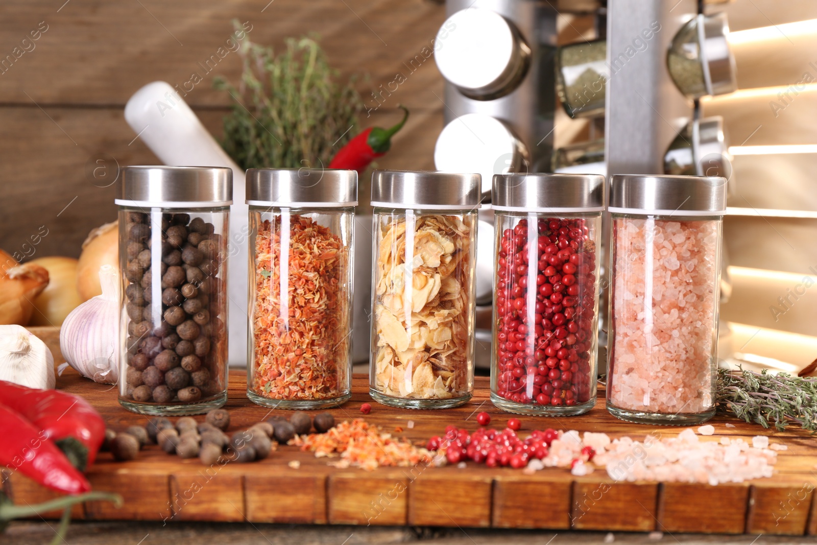 Photo of Different spices and glass jars and on wooden table, closeup