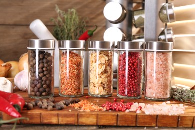 Photo of Different spices and glass jars and on wooden table, closeup