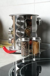 Photo of Set of different spices in glass jars on light grey table in kitchen